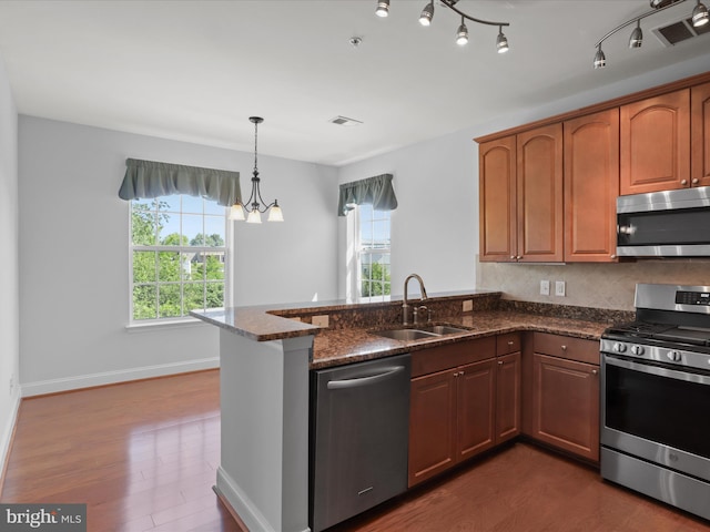 9204 Charleston Dr Unit 407, Manassas, VA 20110 - kitchen featuring stainless steel appliances, a sink, a peninsula, dark stone countertops, and dark wood-style flooring