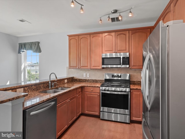 9204 Charleston Dr Unit 407, Manassas, VA 20110 - kitchen with appliances with stainless steel finishes, a sink, dark stone counters, light wood-type flooring, and a peninsula