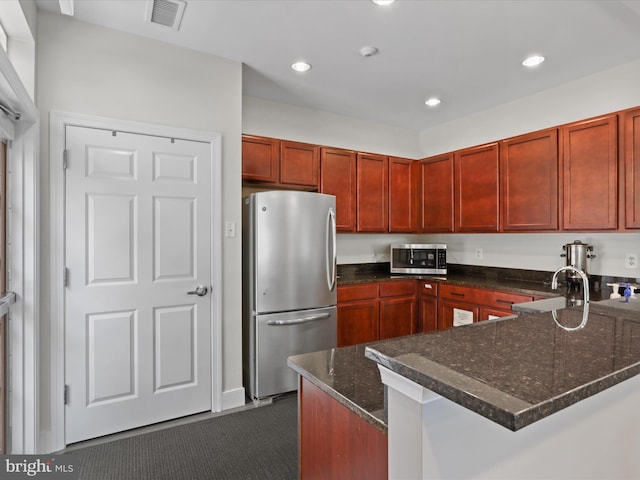 9204 Charleston Dr Unit 407, Manassas, VA 20110 - kitchen featuring appliances with stainless steel finishes, a sink, dark stone countertops, dark carpet, and recessed lighting