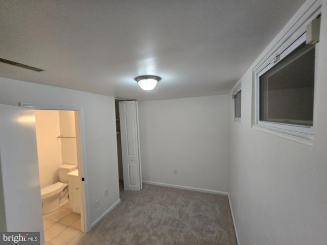 7657 Sheffield Village Ln, Lorton, VA 22079 - unfurnished bedroom featuring baseboards, light carpet, and connected bathroom