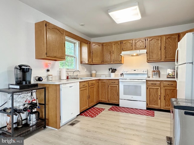 8565 E St, Chesapeake Beach, MD 20732 - kitchen featuring white appliances, under cabinet range hood, a sink, light wood-style flooring, and light countertops