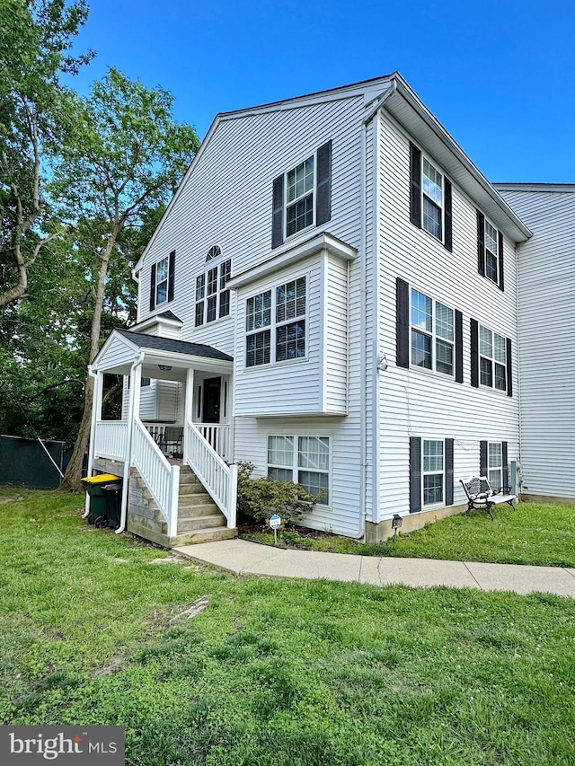 8565 E St, Chesapeake Beach, MD 20732 - view of front facade featuring covered porch and a front lawn