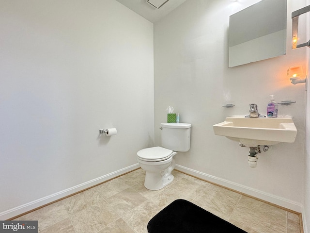 8565 E St, Chesapeake Beach, MD 20732 - bathroom featuring toilet, baseboards, tile patterned floors, and a sink