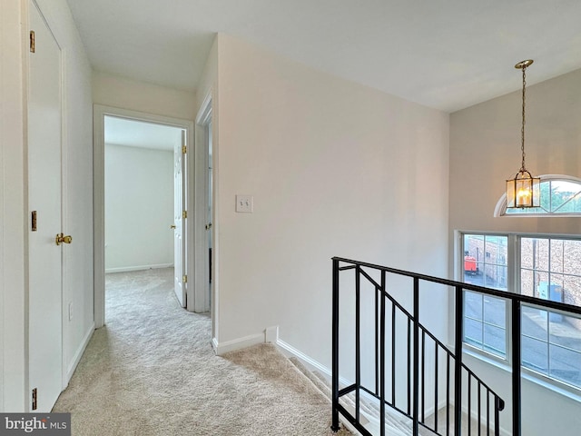 8565 E St, Chesapeake Beach, MD 20732 - corridor with an upstairs landing, carpet, baseboards, and a chandelier