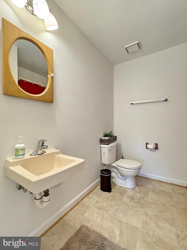 8565 E St, Chesapeake Beach, MD 20732 - bathroom with a sink, toilet, and baseboards