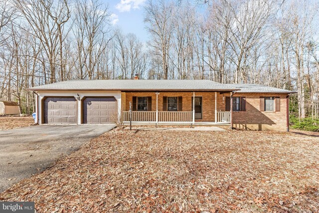 15180 Deborah Dr, Hughesville, MD 20637 - single story home with a porch, an attached garage, driveway, brick siding, and a chimney