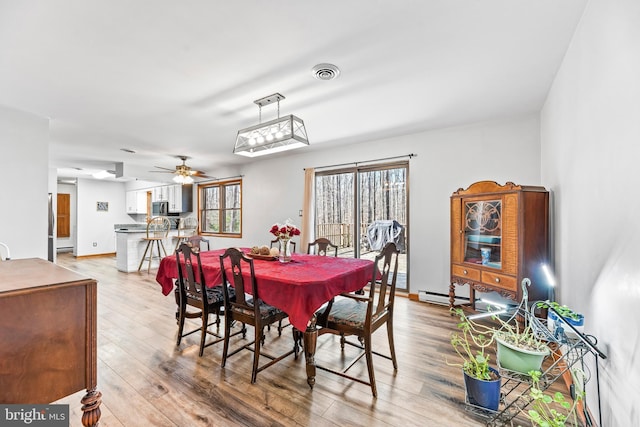 15180 Deborah Dr, Hughesville, MD 20637 - dining area featuring a baseboard radiator, light wood-style flooring, and a ceiling fan
