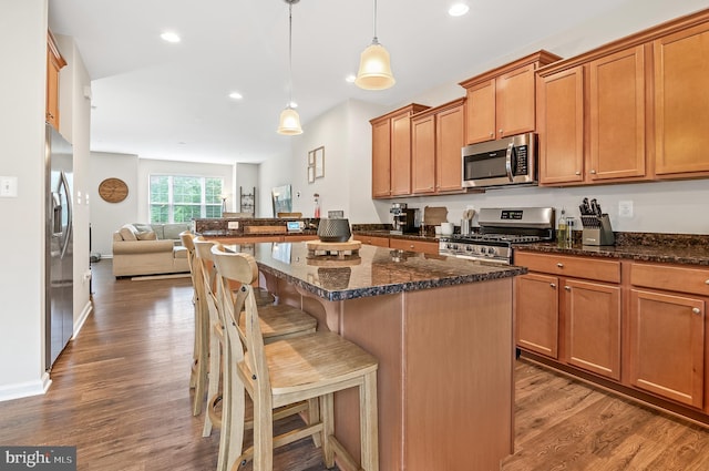 1022 Linden Dr, Hanover, MD 21076 - kitchen with appliances with stainless steel finishes, open floor plan, wood finished floors, a breakfast bar area, and recessed lighting