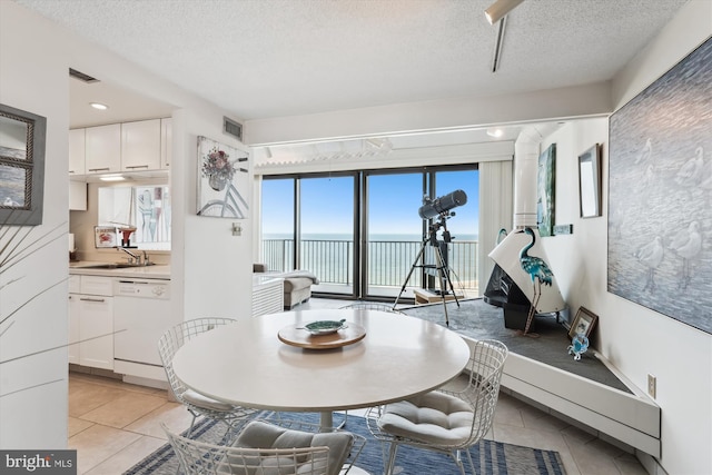 902 Dover House Rd Unit 902S, Bethany Beach, DE 19930 - dining area featuring a textured ceiling, a water view, and light tile patterned floors