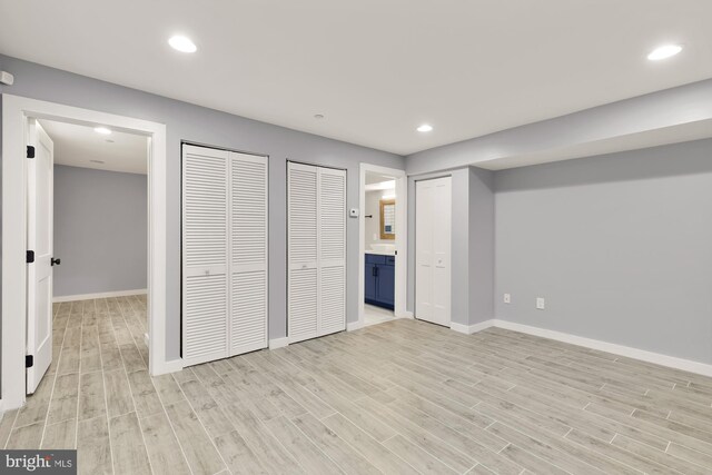909 Webster St NW Unit 1, Washington, DC 20011 - unfurnished bedroom featuring light wood-type flooring, baseboards, ensuite bathroom, recessed lighting, and two closets