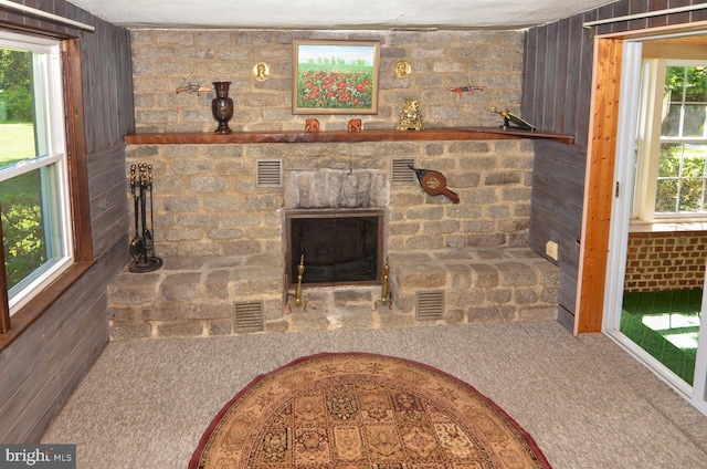 1009 Potts Mill Rd, Bordentown, NJ 08505 - unfurnished living room featuring carpet, wood walls, and a stone fireplace