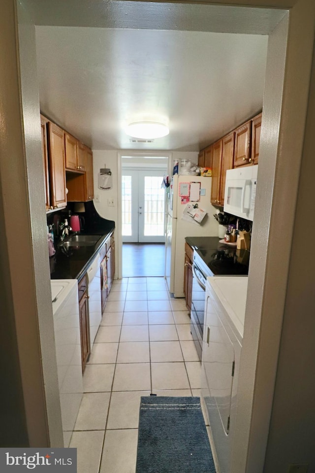 2460 Kilpatrick Pl, Dumfries, VA 22026 - kitchen featuring white appliances, washing machine and clothes dryer, a sink, light tile patterned floors, and french doors