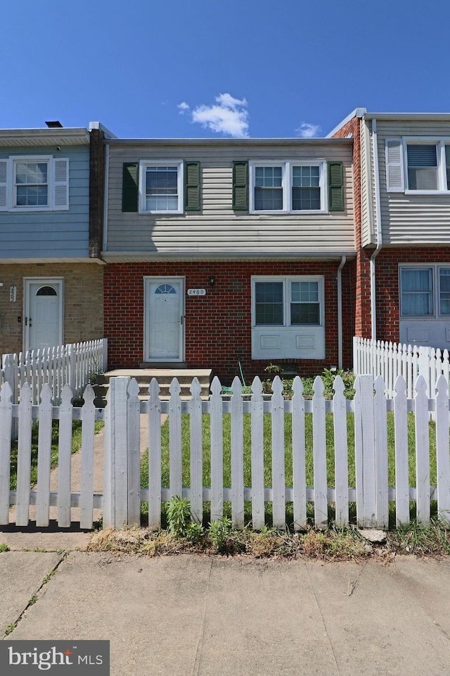 2460 Kilpatrick Pl, Dumfries, VA 22026 - townhome / multi-family property featuring brick siding and a fenced front yard