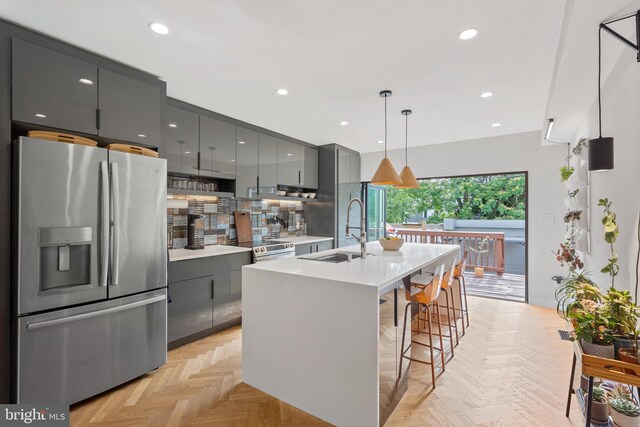 2426 4th St NE, Washington, DC 20002 - kitchen with stainless steel fridge with ice dispenser, gray cabinetry, a sink, a kitchen island with sink, and light countertops