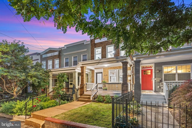 2426 4th St NE, Washington, DC 20002 - view of property with a porch, a fenced front yard, and brick siding