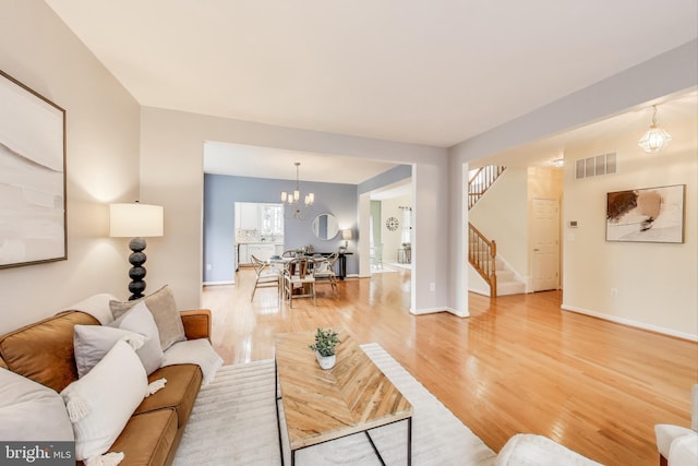 35551 Sarasota St, Round Hill, VA 20141 - living area with stairs, light wood-style flooring, a chandelier, and baseboards