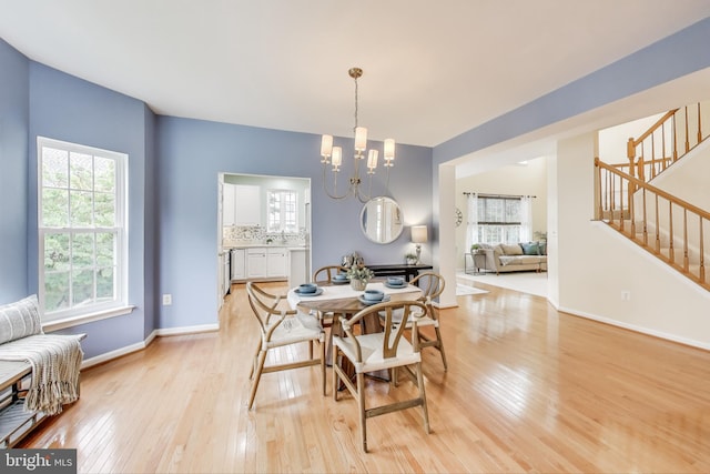 35551 Sarasota St, Round Hill, VA 20141 - dining room featuring light wood finished floors, a chandelier, stairway, and baseboards