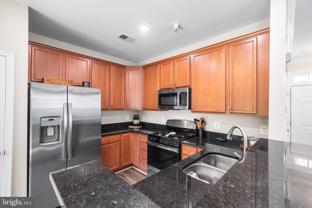 43825 Hickory Corner Ter Unit 104, Ashburn, VA 20147 - kitchen with appliances with stainless steel finishes, a sink, dark stone counters, brown cabinets, and recessed lighting