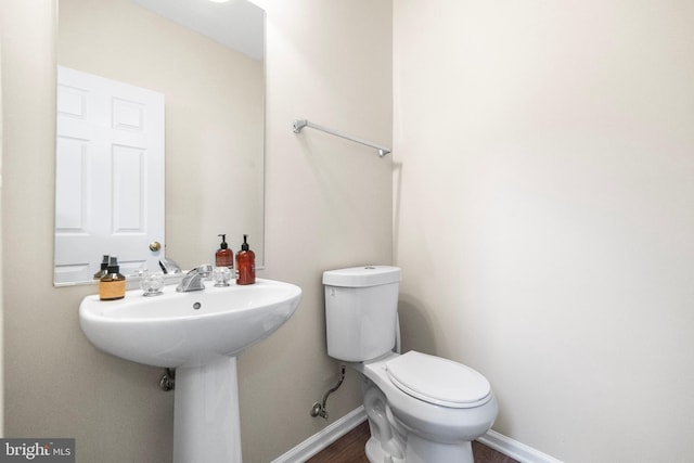 43825 Hickory Corner Ter Unit 104, Ashburn, VA 20147 - half bathroom featuring toilet, baseboards, and wood finished floors