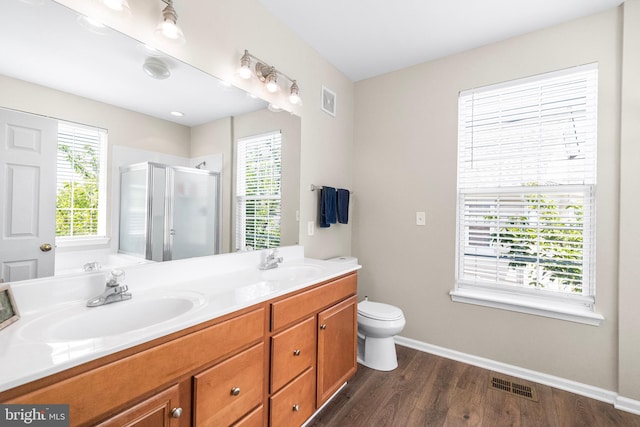 43825 Hickory Corner Ter Unit 104, Ashburn, VA 20147 - bathroom featuring a shower stall, wood finished floors, baseboards, double vanity, and toilet
