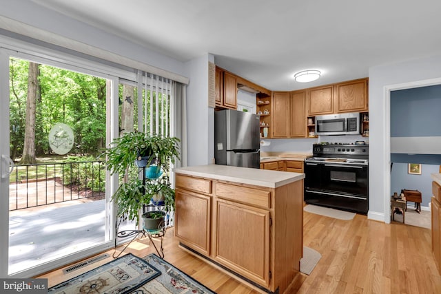 4097 Shoreham Beach Rd, Edgewater, MD 21037 - kitchen featuring appliances with stainless steel finishes, open shelves, light countertops, and plenty of natural light