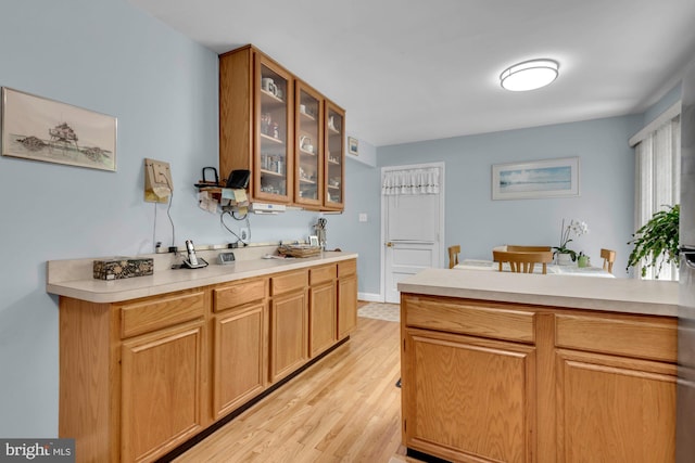 4097 Shoreham Beach Rd, Edgewater, MD 21037 - kitchen with light countertops, glass insert cabinets, light wood-style flooring, and a peninsula