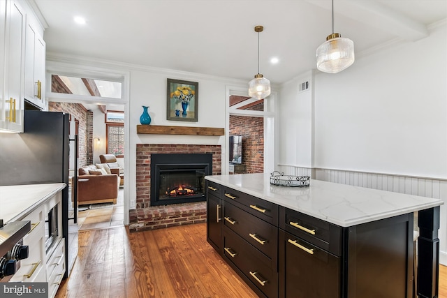 1157 Riverside Ave, Baltimore, MD 21230 - kitchen featuring white cabinets, wood finished floors, a fireplace, open floor plan, and pendant lighting