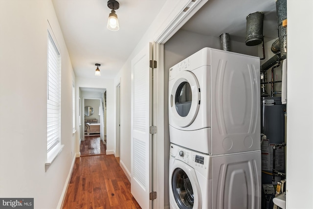 1157 Riverside Ave, Baltimore, MD 21230 - laundry room featuring stacked washer and clothes dryer, wood finished floors, and baseboards