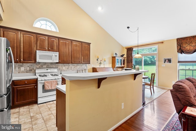 4 Hearthstone Blvd, Pemberton, NJ 08068 - kitchen with white appliances, high vaulted ceiling, a breakfast bar, light countertops, and pendant lighting