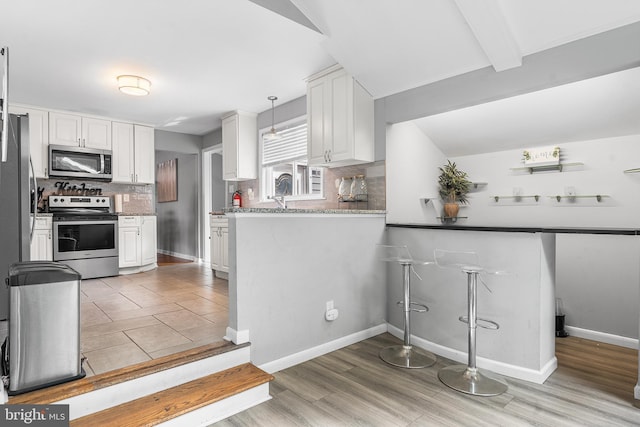 521 Rhode Island Ave, Cherry Hill, NJ 08002 - kitchen with appliances with stainless steel finishes, decorative backsplash, white cabinets, light wood finished floors, and baseboards