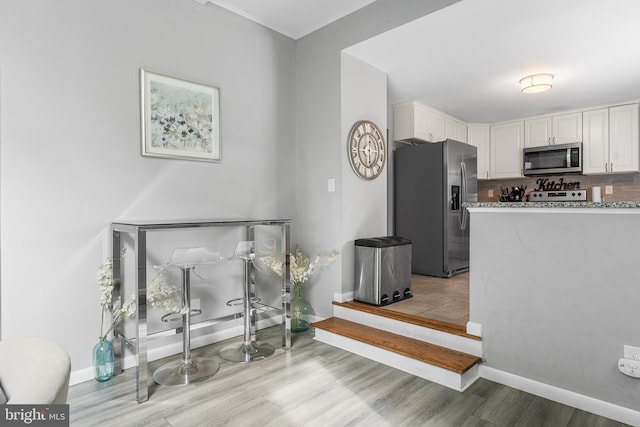 521 Rhode Island Ave, Cherry Hill, NJ 08002 - kitchen featuring stainless steel appliances, white cabinets, light wood finished floors, baseboards, and light stone countertops