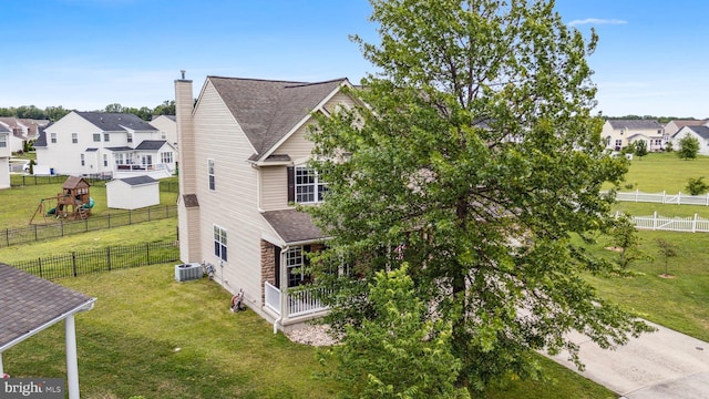 39 Grain Ct, Magnolia, DE 19962 - view of side of property with a chimney, central AC unit, a residential view, a shingled roof, and a playground