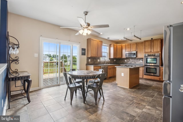 39 Grain Ct, Magnolia, DE 19962 - kitchen featuring appliances with stainless steel finishes, decorative backsplash, a center island, ceiling fan, and a sink
