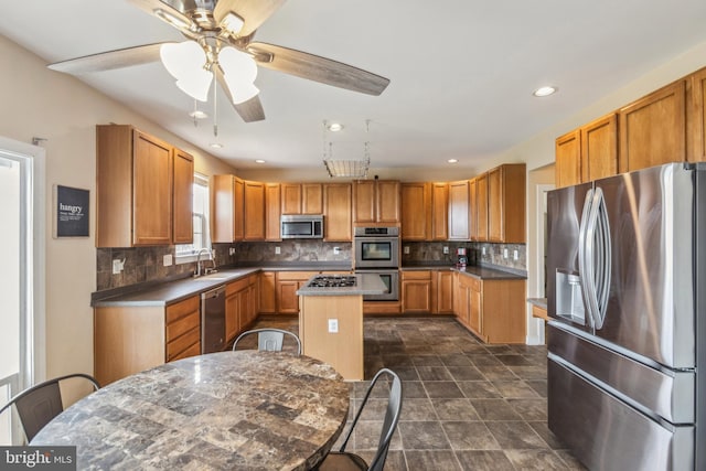 39 Grain Ct, Magnolia, DE 19962 - kitchen with stainless steel appliances, a sink, a center island, decorative backsplash, and a ceiling fan