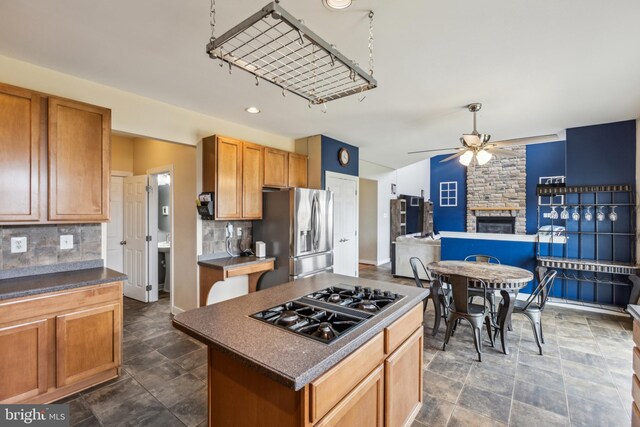 39 Grain Ct, Magnolia, DE 19962 - kitchen with stainless steel fridge with ice dispenser, black gas stovetop, a ceiling fan, a fireplace, and dark countertops