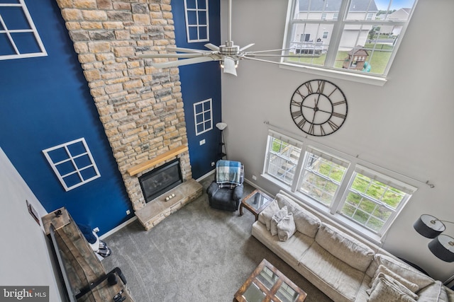 39 Grain Ct, Magnolia, DE 19962 - carpeted living room featuring a fireplace, a high ceiling, a ceiling fan, and baseboards