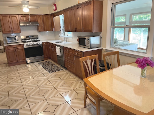 333 Sussex Blvd, Broomall, PA 19008 - kitchen with appliances with stainless steel finishes, under cabinet range hood, a sink, backsplash, and light countertops