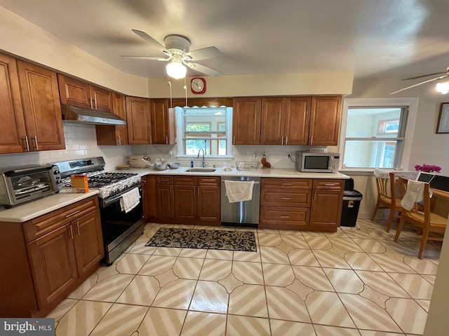 333 Sussex Blvd, Broomall, PA 19008 - kitchen featuring stainless steel appliances, a ceiling fan, under cabinet range hood, light tile patterned floors, and decorative backsplash