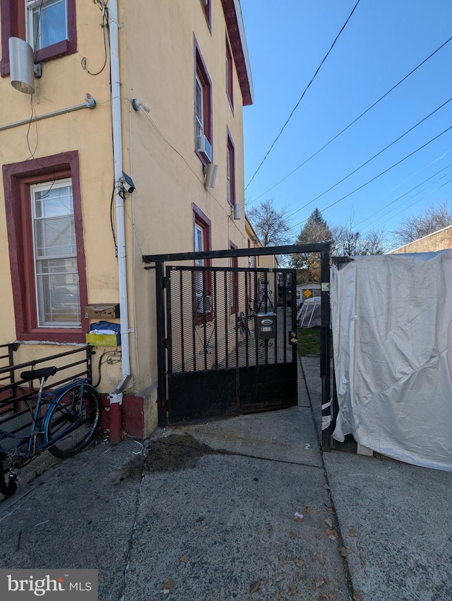 3228 N Sydenham St, Philadelphia, PA 19134 - view of side of property featuring stucco siding and a gate