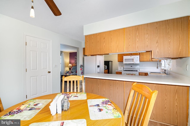 114 Austin Dr, Enola, PA 17025 - kitchen featuring white appliances, light countertops, a sink, a peninsula, and brown cabinets
