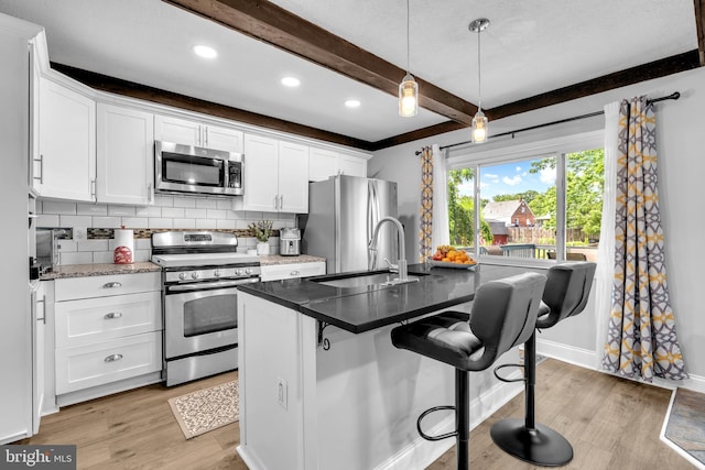 204 Kuethe Rd NE, Glen Burnie, MD 21060 - kitchen with appliances with stainless steel finishes, beam ceiling, backsplash, light wood-style floors, and a sink