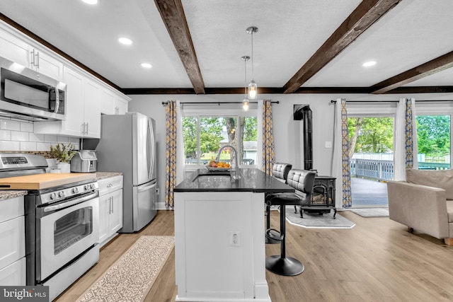 204 Kuethe Rd NE, Glen Burnie, MD 21060 - kitchen featuring appliances with stainless steel finishes, a sink, a wood stove, light wood-style flooring, and beam ceiling