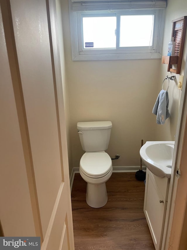 3755 Morrow Dr, Bensalem, PA 19020 - half bathroom with vanity, plenty of natural light, toilet, and wood finished floors