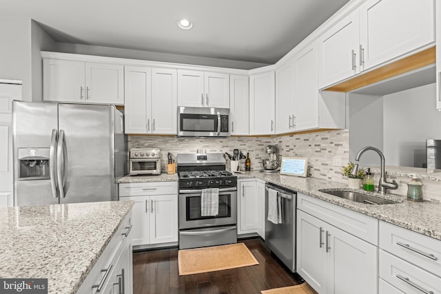 7250 Calm Sunset, Columbia, MD 21046 - kitchen featuring appliances with stainless steel finishes, a sink, white cabinetry, dark wood-style floors, and recessed lighting