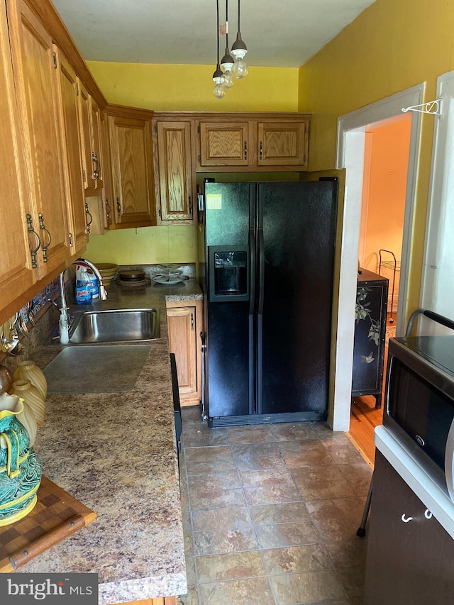6136 Wayne Ave Unit 3, Philadelphia, PA 19144 - kitchen featuring black fridge, a sink, brown cabinetry, hanging light fixtures, and light countertops