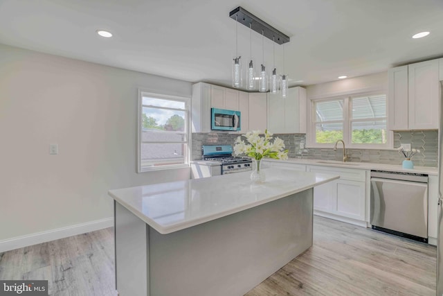 611 Parkview Blvd, Lansdowne, PA 19050 - kitchen with appliances with stainless steel finishes, a sink, backsplash, white cabinetry, and light wood finished floors