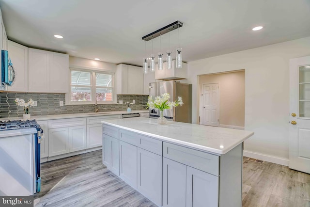 611 Parkview Blvd, Lansdowne, PA 19050 - kitchen featuring stainless steel appliances, a sink, light wood-style flooring, backsplash, and white cabinets