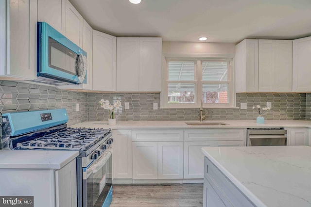 611 Parkview Blvd, Lansdowne, PA 19050 - kitchen featuring stainless steel appliances, a sink, white cabinetry, light wood finished floors, and recessed lighting