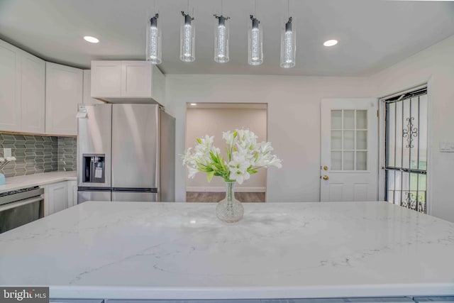 611 Parkview Blvd, Lansdowne, PA 19050 - kitchen featuring stainless steel fridge with ice dispenser, white cabinets, light stone countertops, tasteful backsplash, and decorative light fixtures