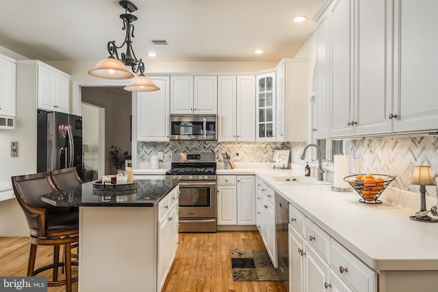 1597 Woodfield Dr, Bethlehem, PA 18015 - kitchen with appliances with stainless steel finishes, a sink, a breakfast bar area, a kitchen island, and backsplash